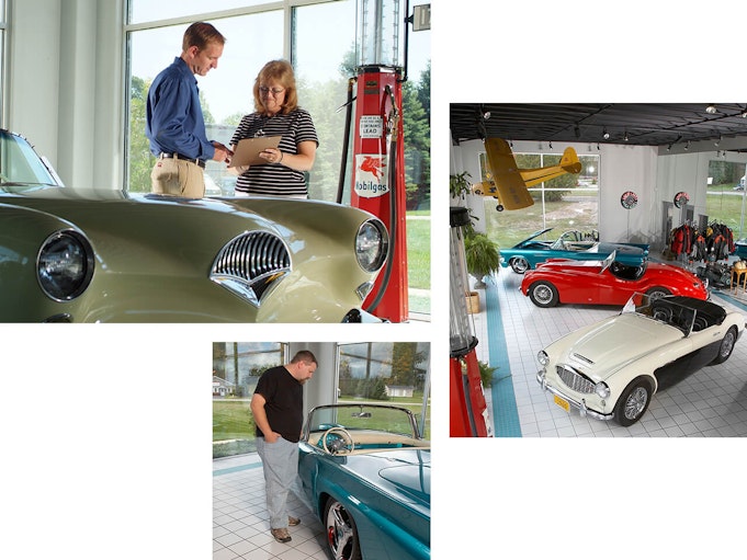 Collector vehicles on display at a dealership with a man giving a woman guidance on her purchase.