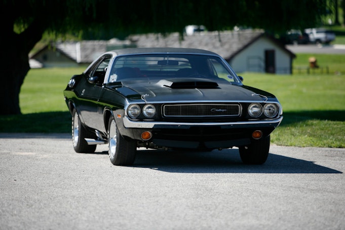 Black Challenger parked facing straight on with trees in background